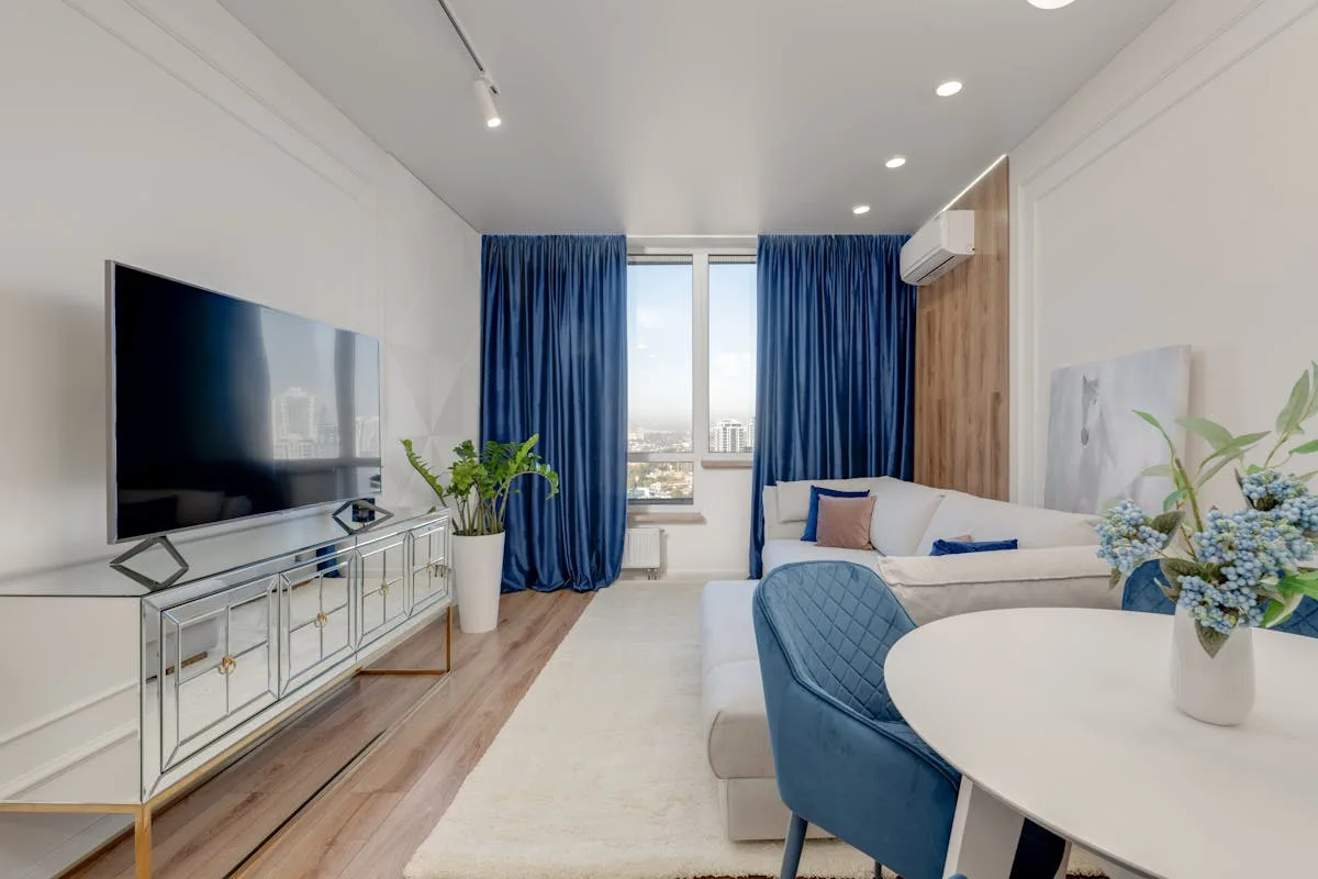 Bright compact apartment living room with a mirrored console and large window