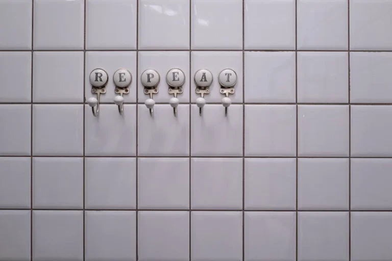 Hooks on a bathroom wall holding towels