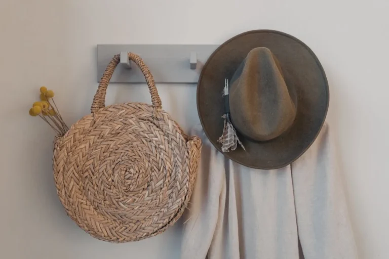 Adhesive wall hooks by an entryway holding coats