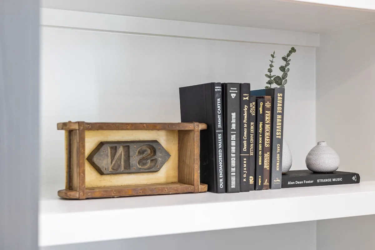 Styled white shelf with books, ceramic vases and eucalyptus in a cohesive neutral palette
