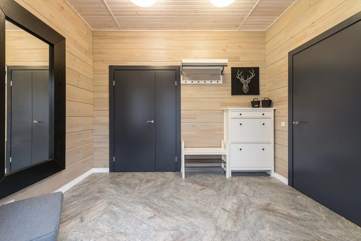 Entryway with a bench and white shoe cabinet for storing shoes in a small apartment