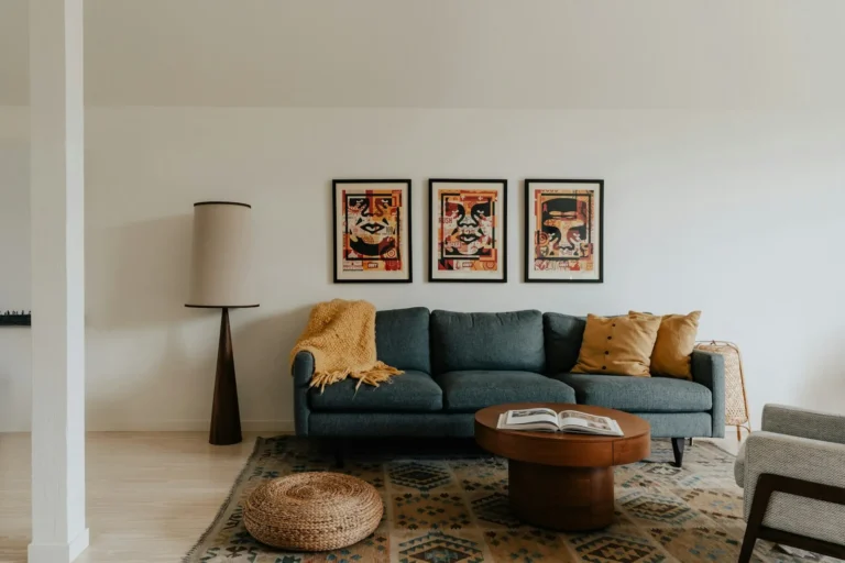 Gallery wall of three framed prints above a sofa in a small apartment