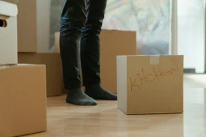 The First Apartment Move-In Checklist (Admin, Utilities, and Deposit Protection) Labeled moving boxes in an empty new apartment on move-in day
