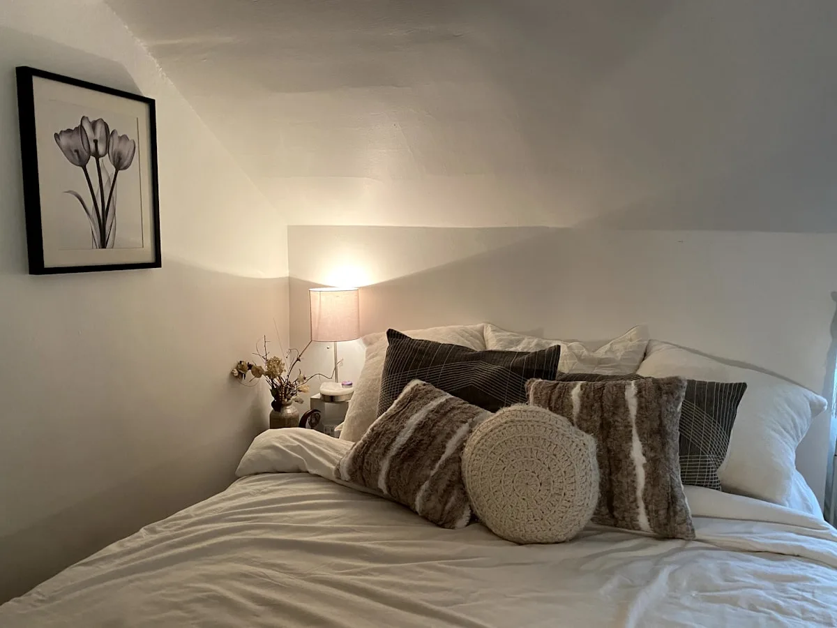 Cozy made bed with a warm lamp set up for the first night in a new apartment