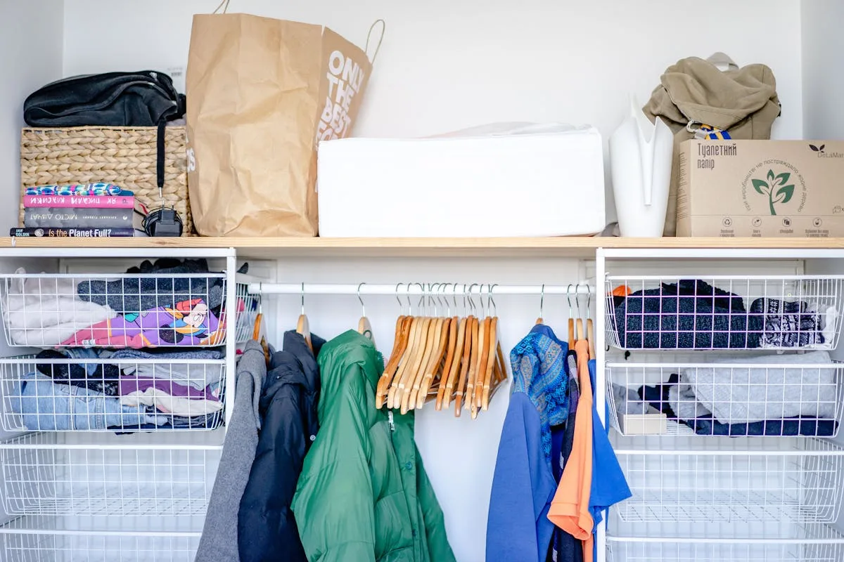 Organized small closet with wire baskets and hanging clothes
