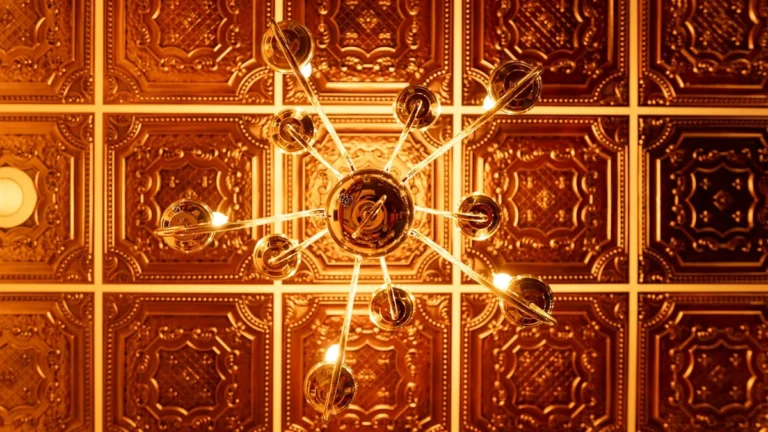Ornate gold pressed-tin ceiling with a vintage chandelier