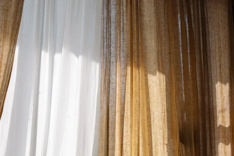 Sheer white linen curtains filtering daylight at a window