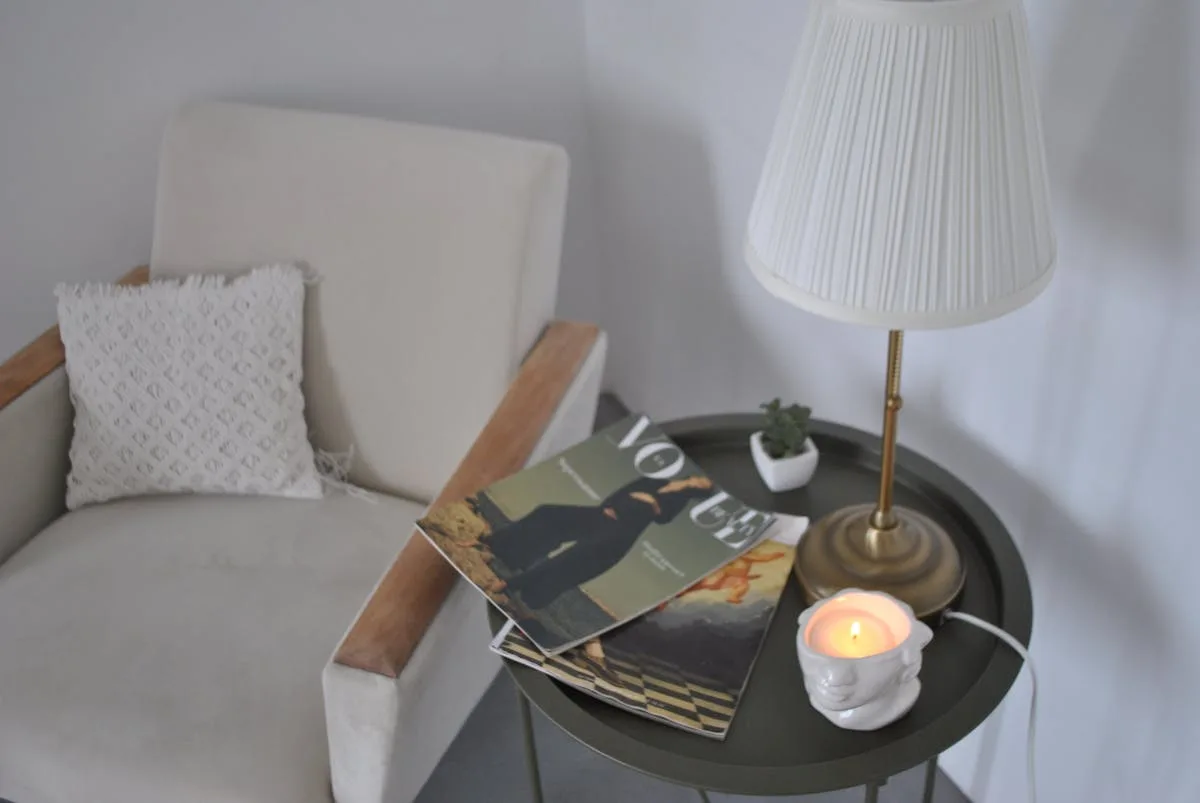 Bright cozy reading corner with an armchair and side table in an apartment