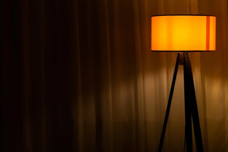 Wood tripod floor lamp lighting a cozy reading corner