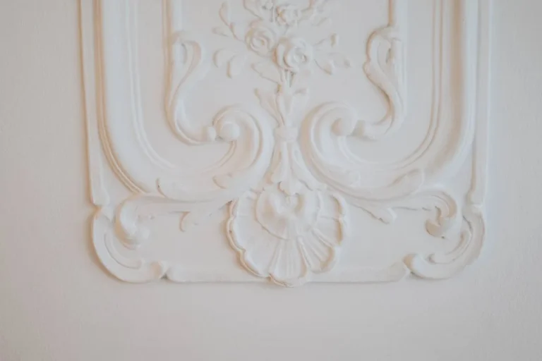 White ornate wall trim with a floral scroll relief close-up