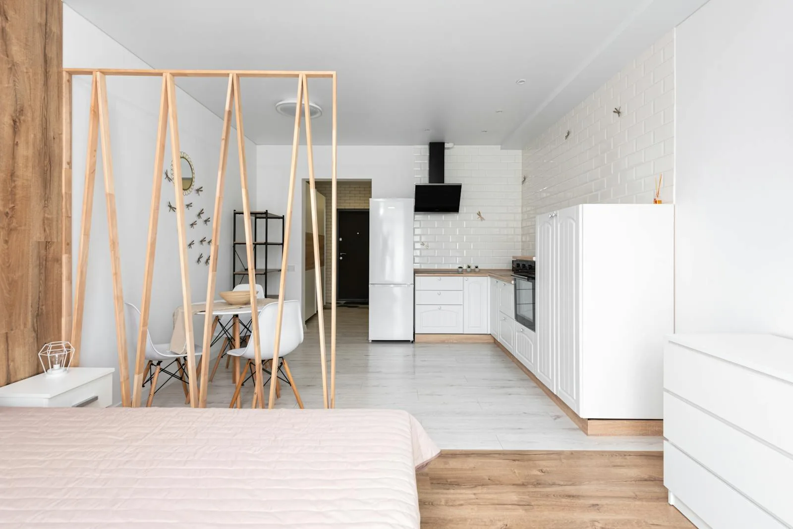Bright studio apartment with a slatted wooden room divider beside the bed