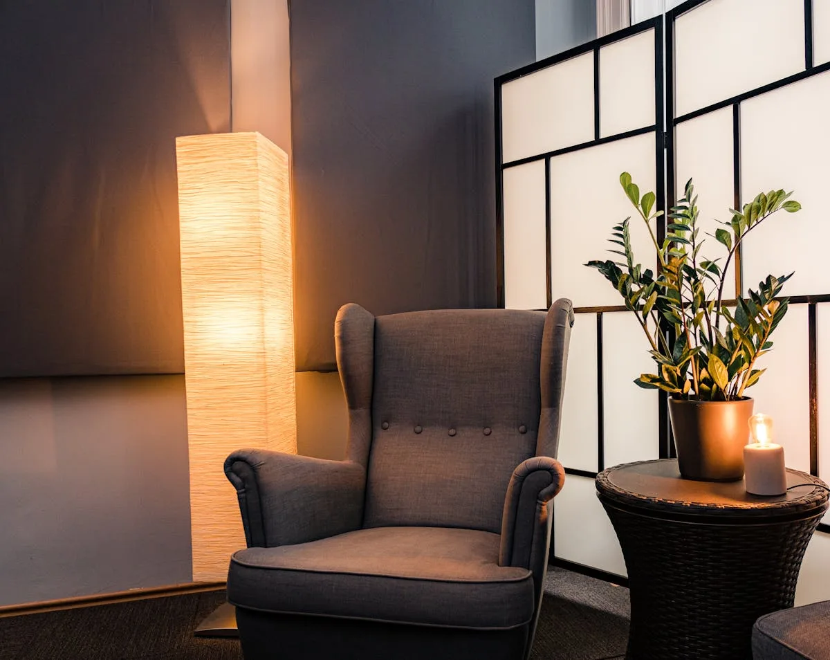 Cozy reading corner divided by a shoji-style folding screen and a warm lamp