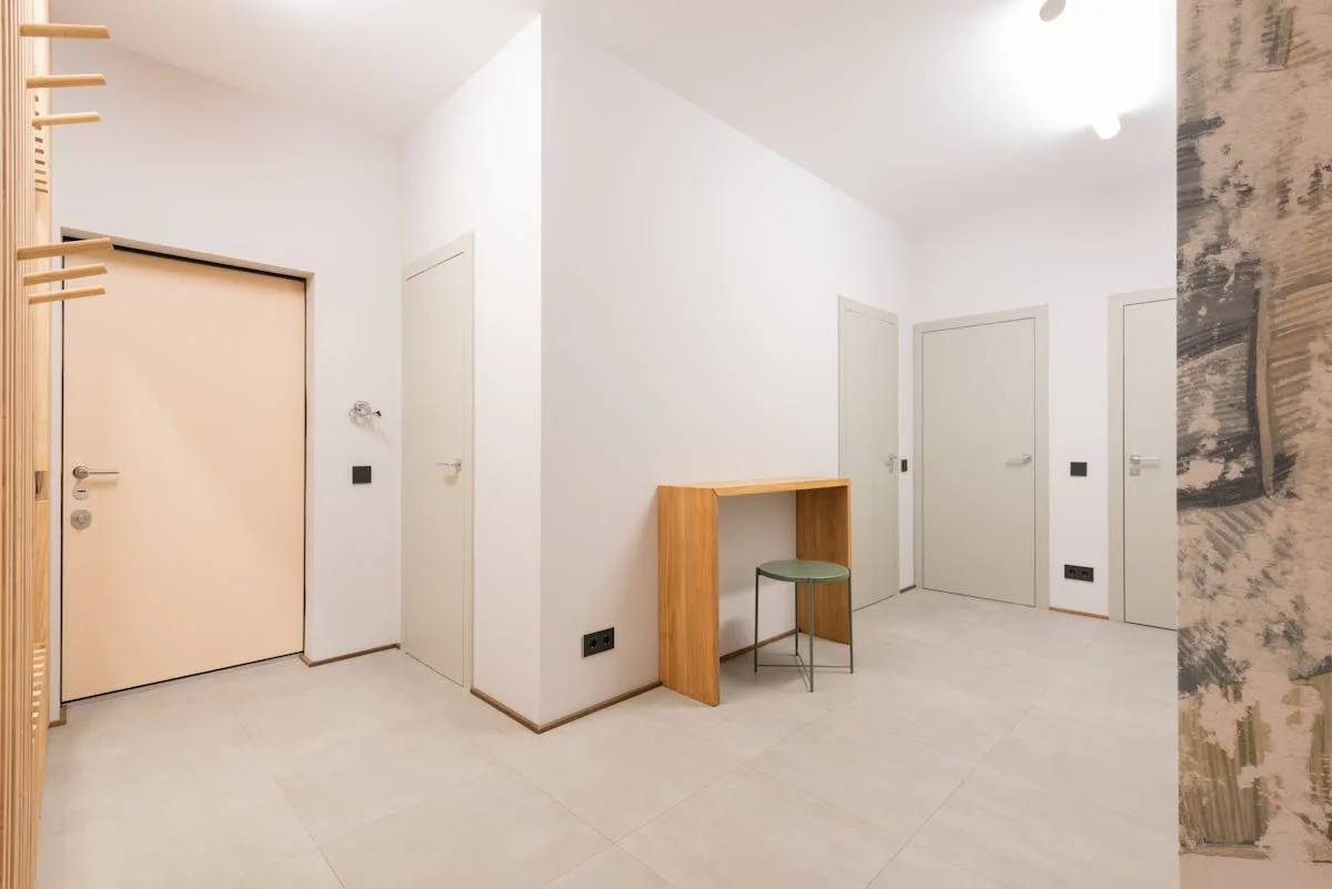 Apartment entryway with peel-and-stick accent wall panel adding texture to a narrow hallway