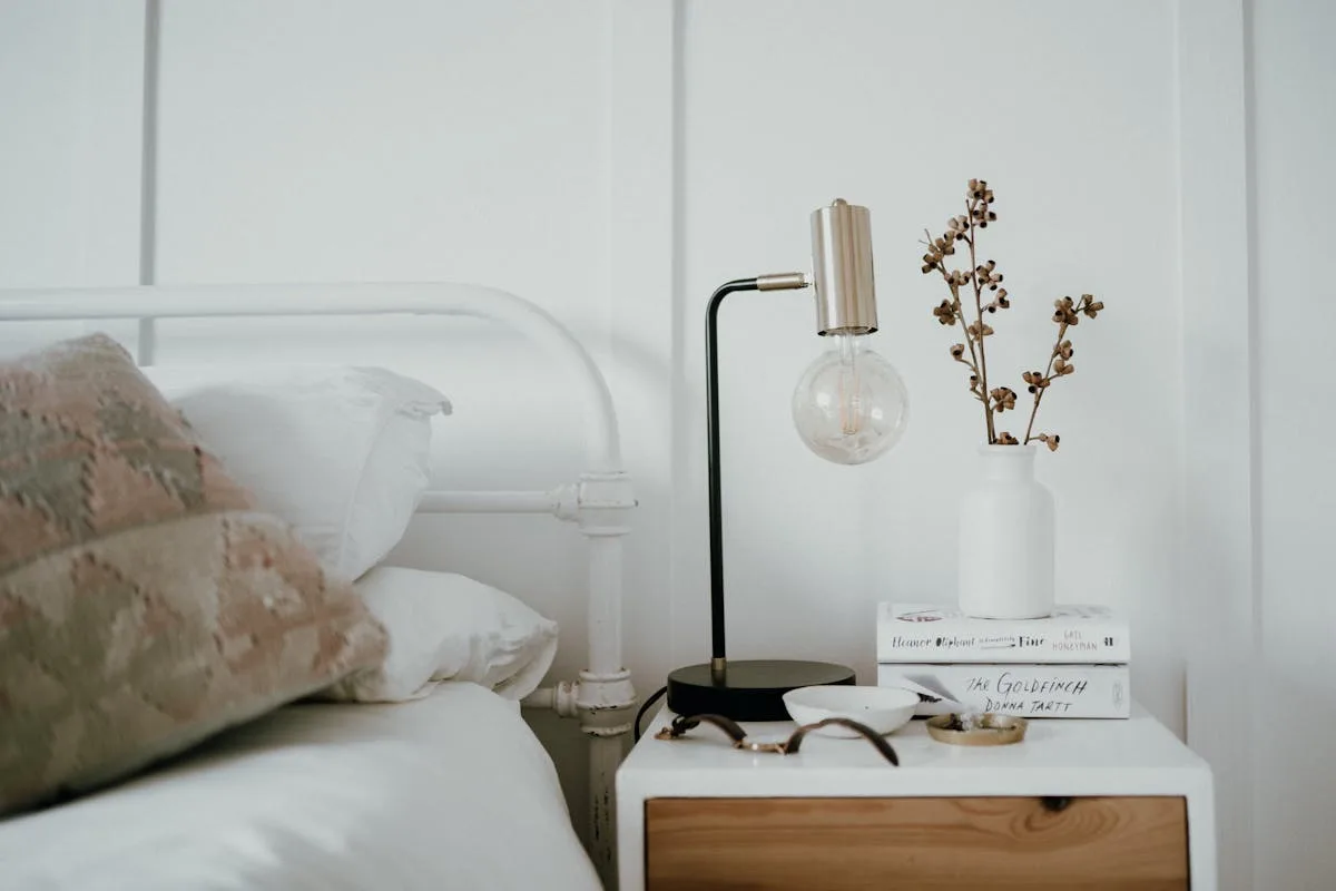 Bright small bedroom with a metal frame bed and a bedside lamp