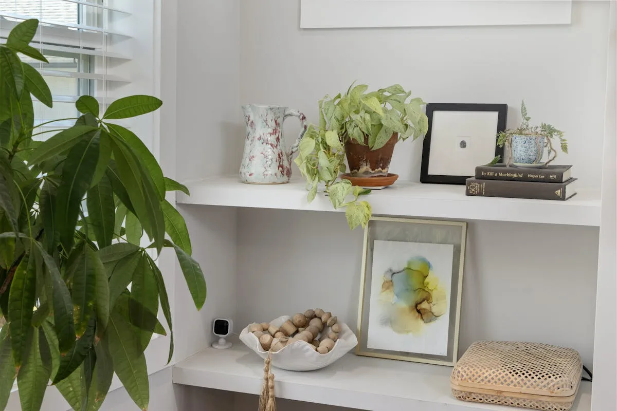 White floating shelves styled with framed art and books on an apartment wall