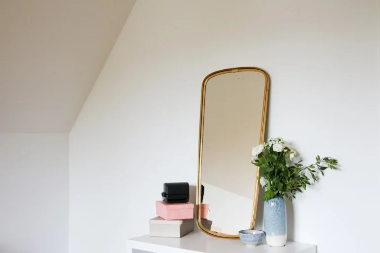 Full-length leaning floor mirror reflecting a bright room