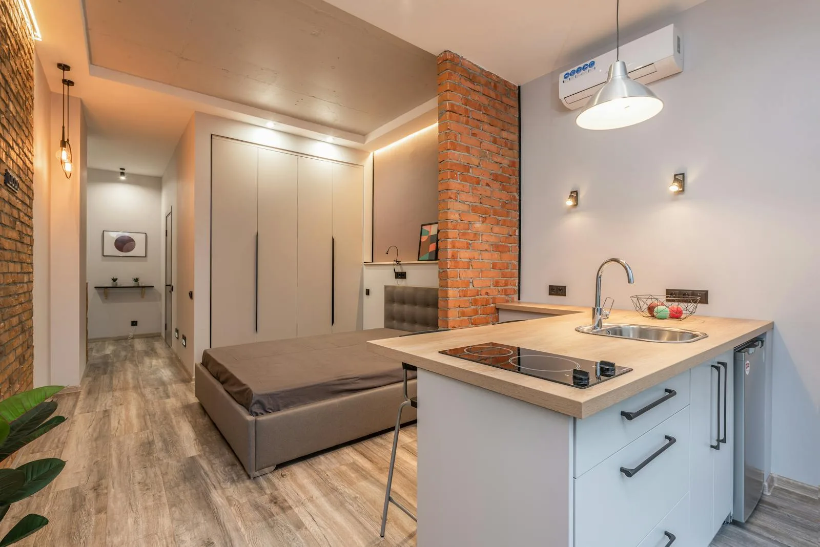Bright warm studio apartment with a bed and a kitchenette along one wall