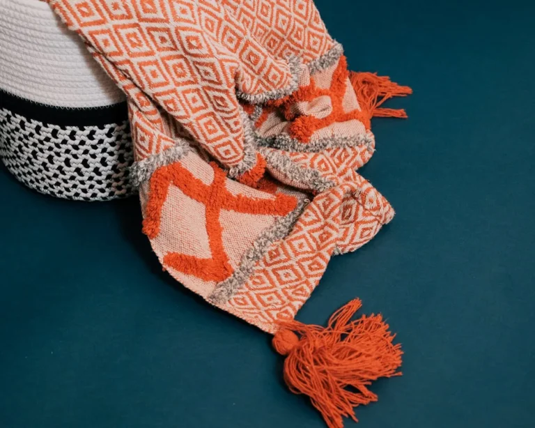 Burnt-orange knit throw draped over a sofa arm