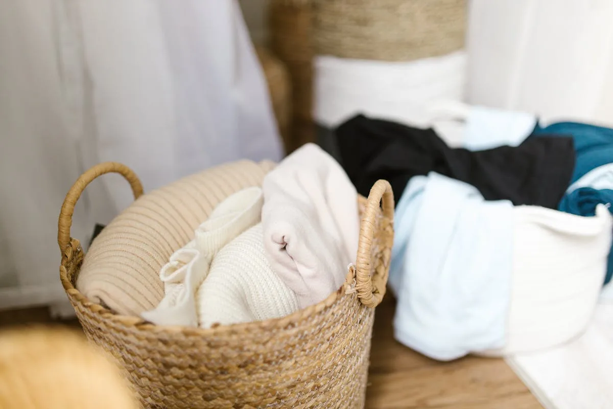 Woven baskets holding neutral folded blankets and clothes for tidy storage