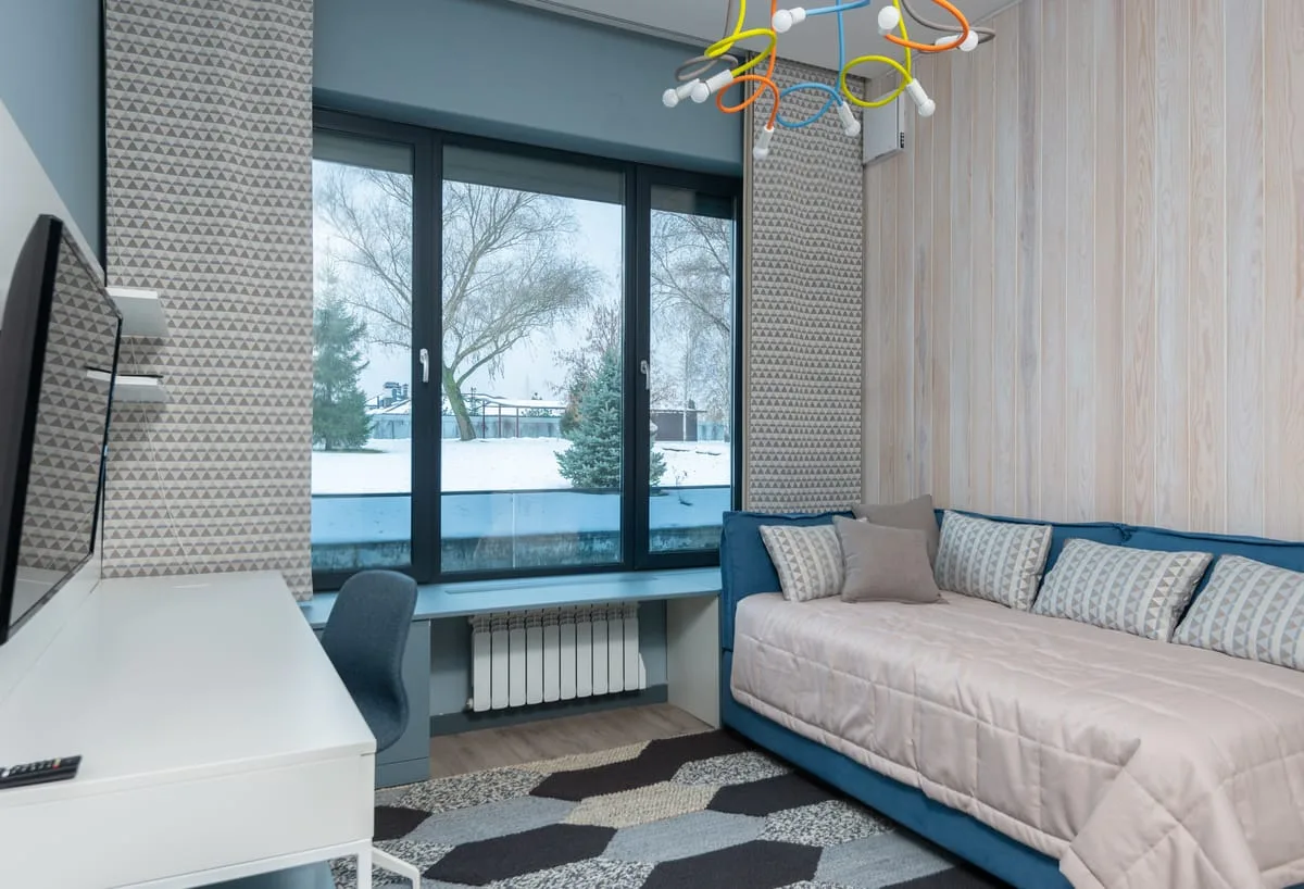 Small bedroom with a daybed that doubles as seating beside a window desk