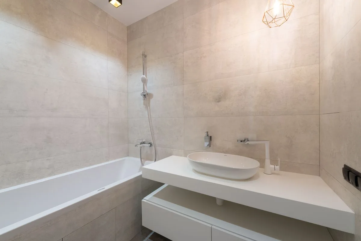 Light neutral bathroom with vanity wall and tub showing renter-friendly peel-and-stick wallpaper candidate zones