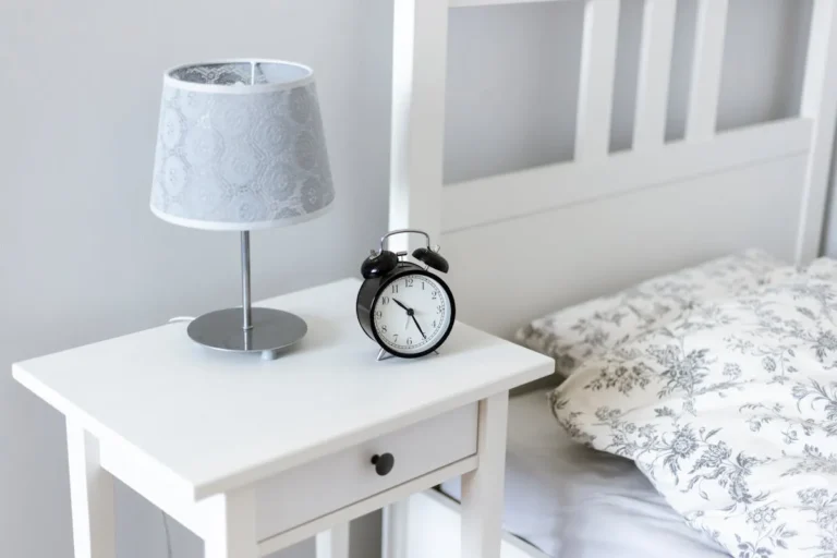 Nightstand with drawers beside a bed