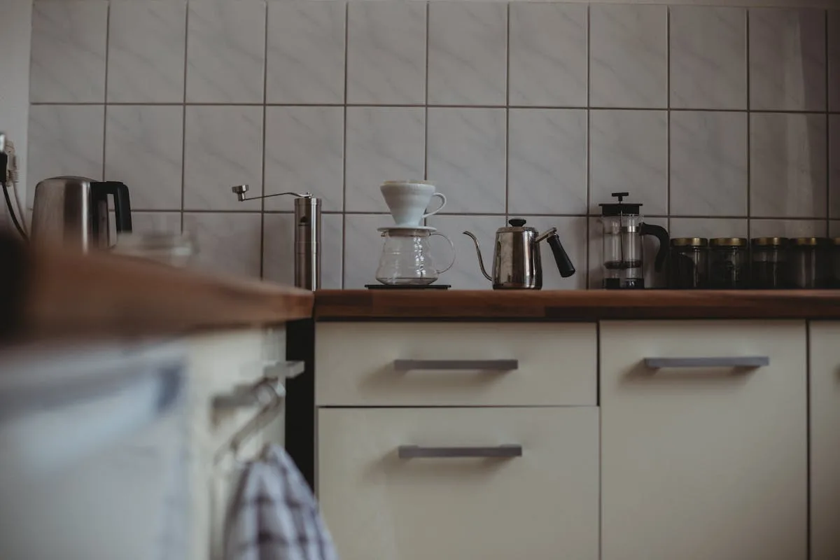 Kitchen coffee station against a square white subway tile backsplash with pour-over kettle and grinder