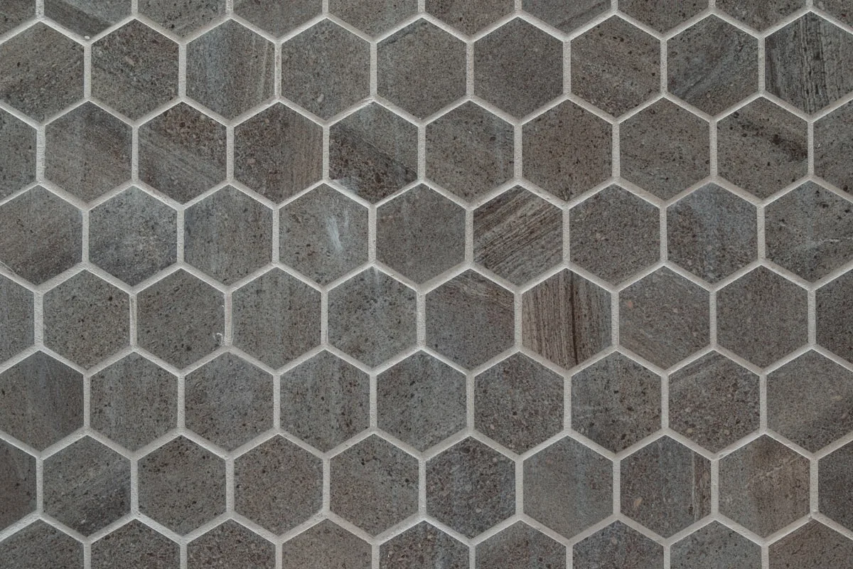 Close-up of grey hexagon mosaic tile backsplash with thin white grout lines