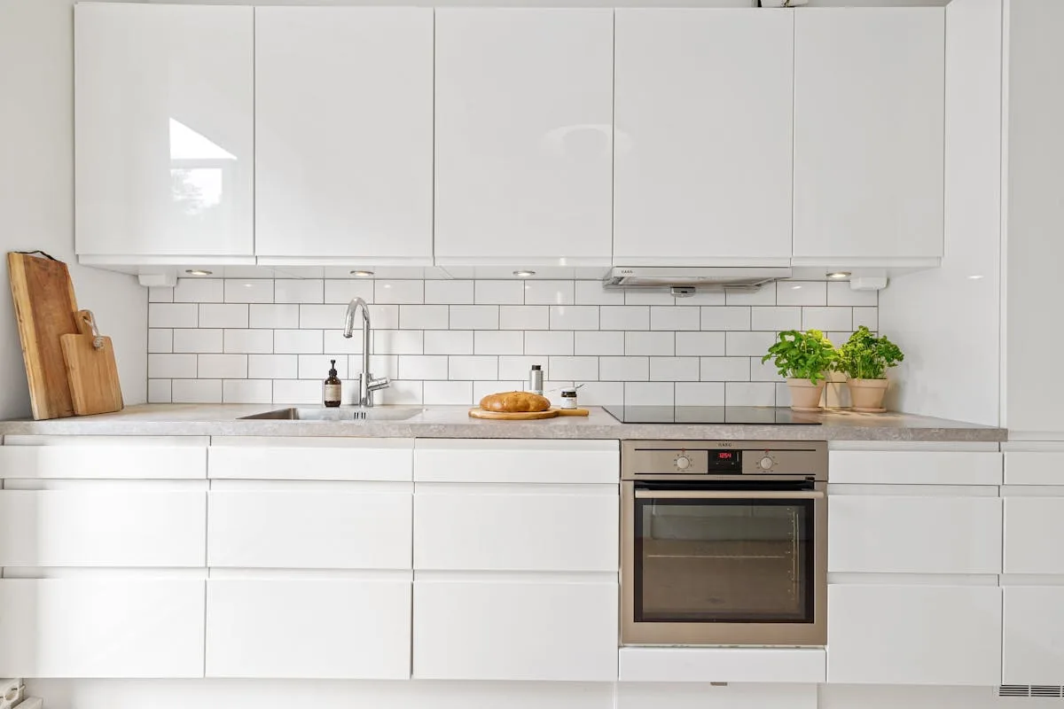 Peel-and-stick mosaic tile backsplash above a kitchen counter in a small apartment
