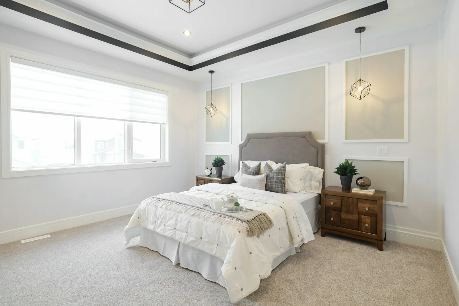 Bright bedroom with a deep tray ceiling and decorative molding details around the perimeter