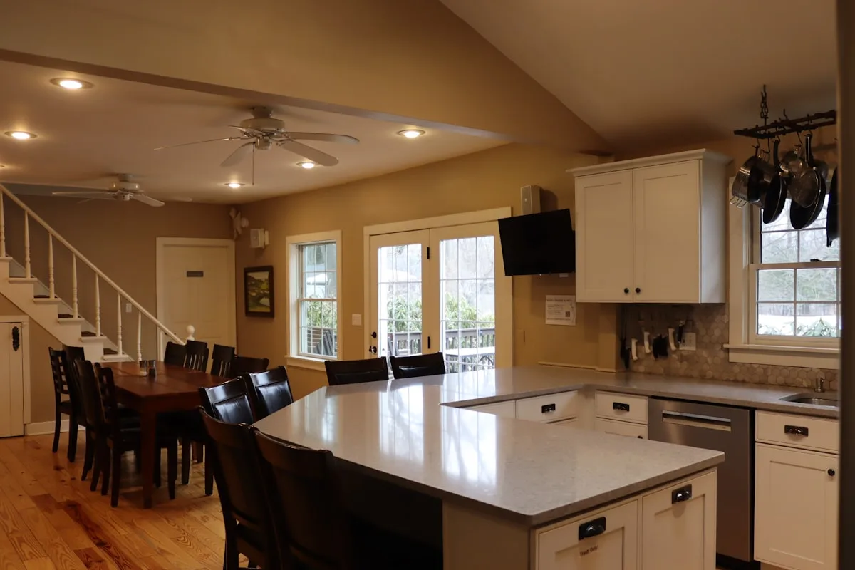 Open kitchen with a vaulted ceiling, ceiling fan and warm overhead lights
