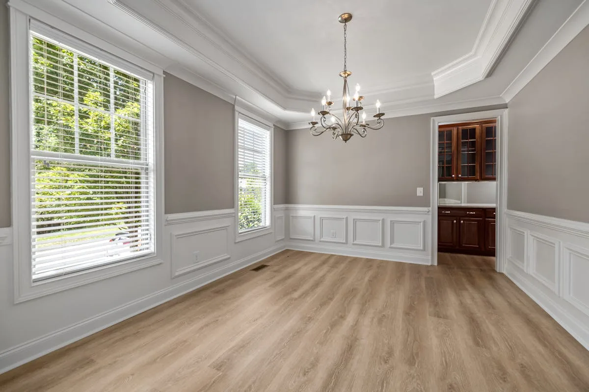 Empty dining room showing the crown molding line along a tray ceiling and chandelier