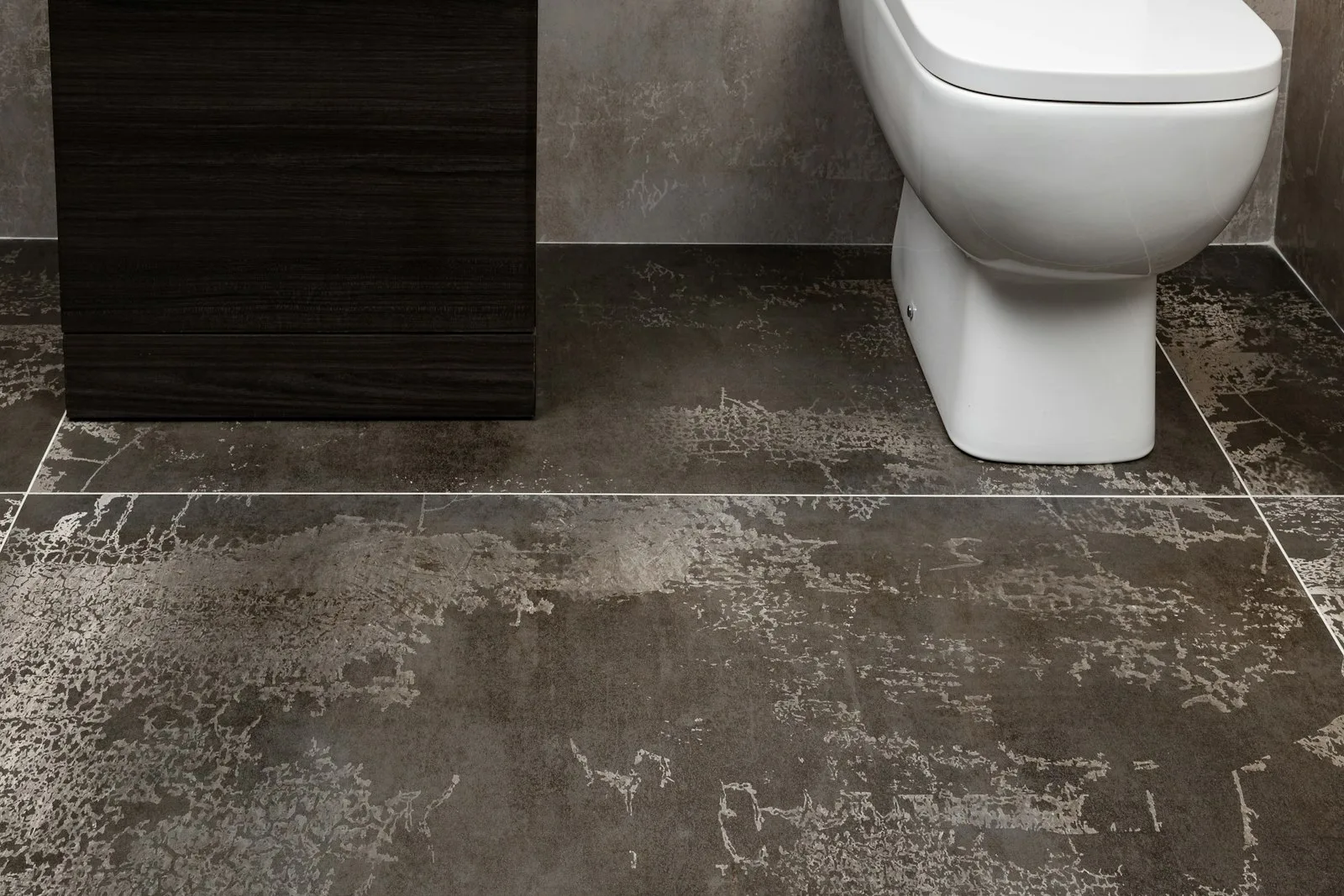 Small rental bathroom with patterned floor tile in muted blue and cream, white subway shower walls