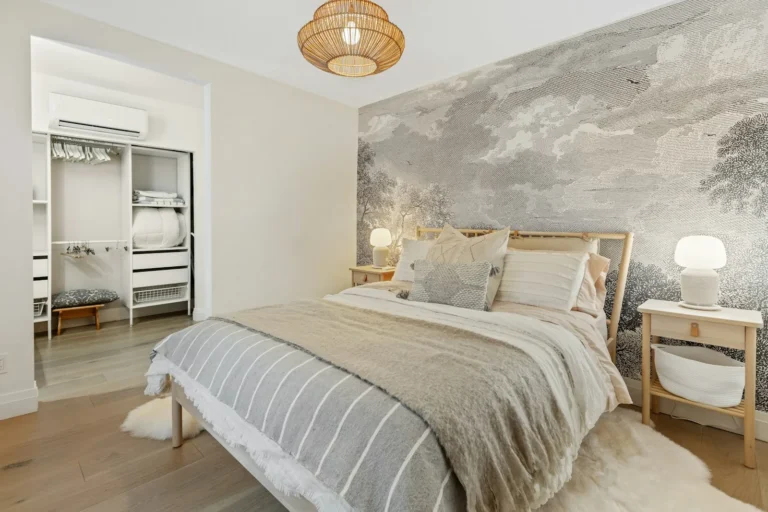 Bedroom with muted tree-pattern removable wallpaper on the wall behind the bed