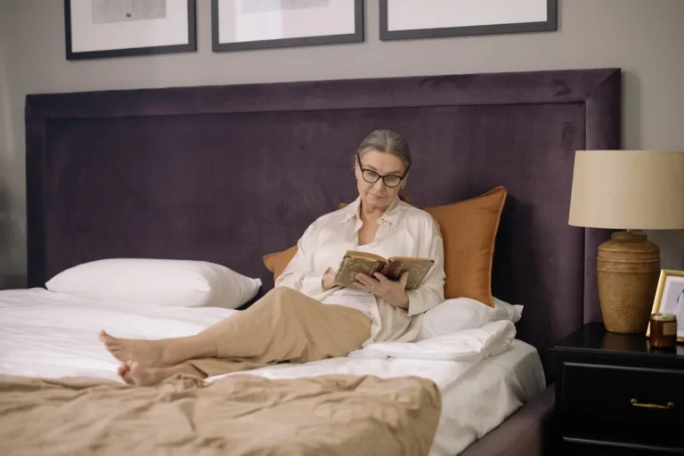 Clip-on reading light attached to a headboard beside a book