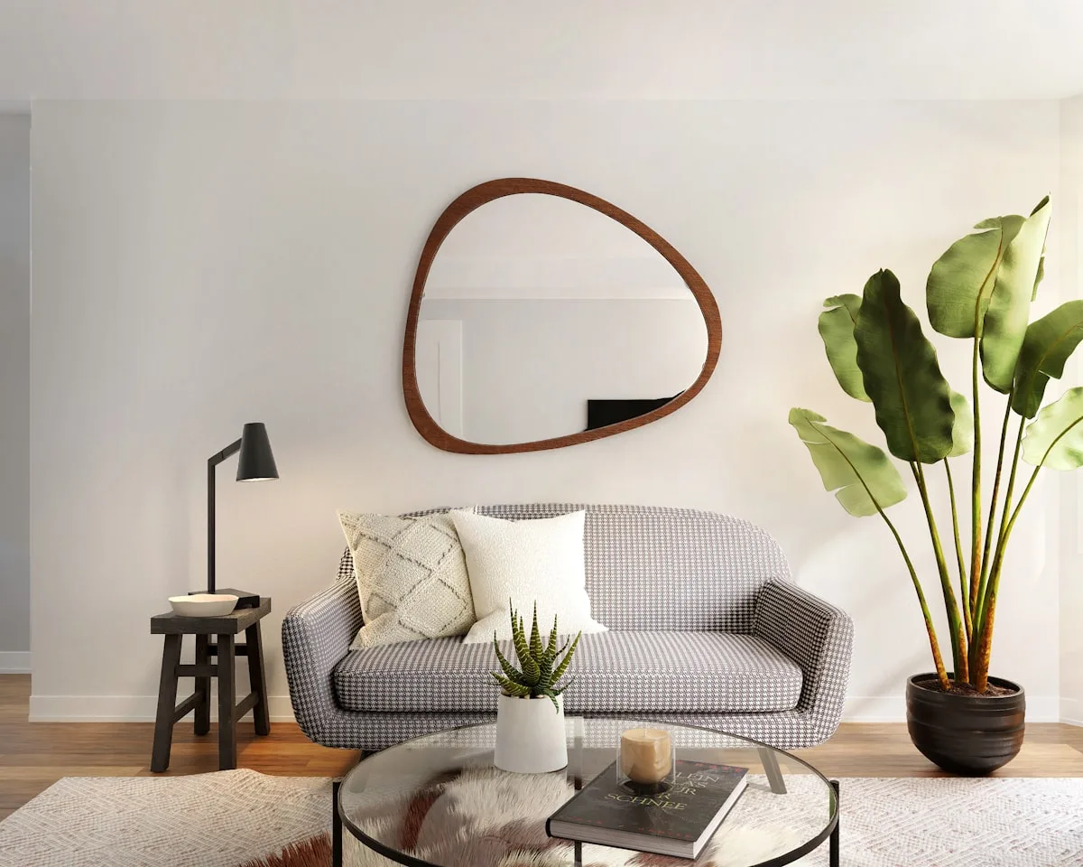 Large round mirror above a sofa bouncing light in a small living room