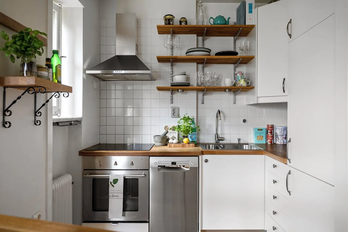 Compact white apartment kitchen with open shelving and butcher block counters