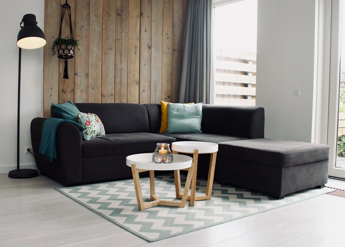 Living room seating zone anchored by a chevron area rug and round nesting tables