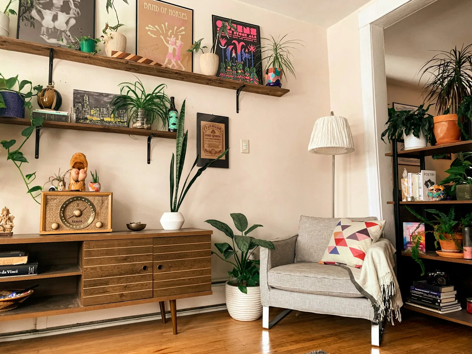 Cozy small apartment corner with wall shelves and a wood sideboard for storage