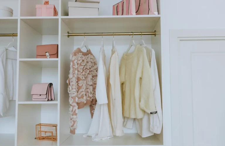 Clothes hanging on a rod in a small open closet
