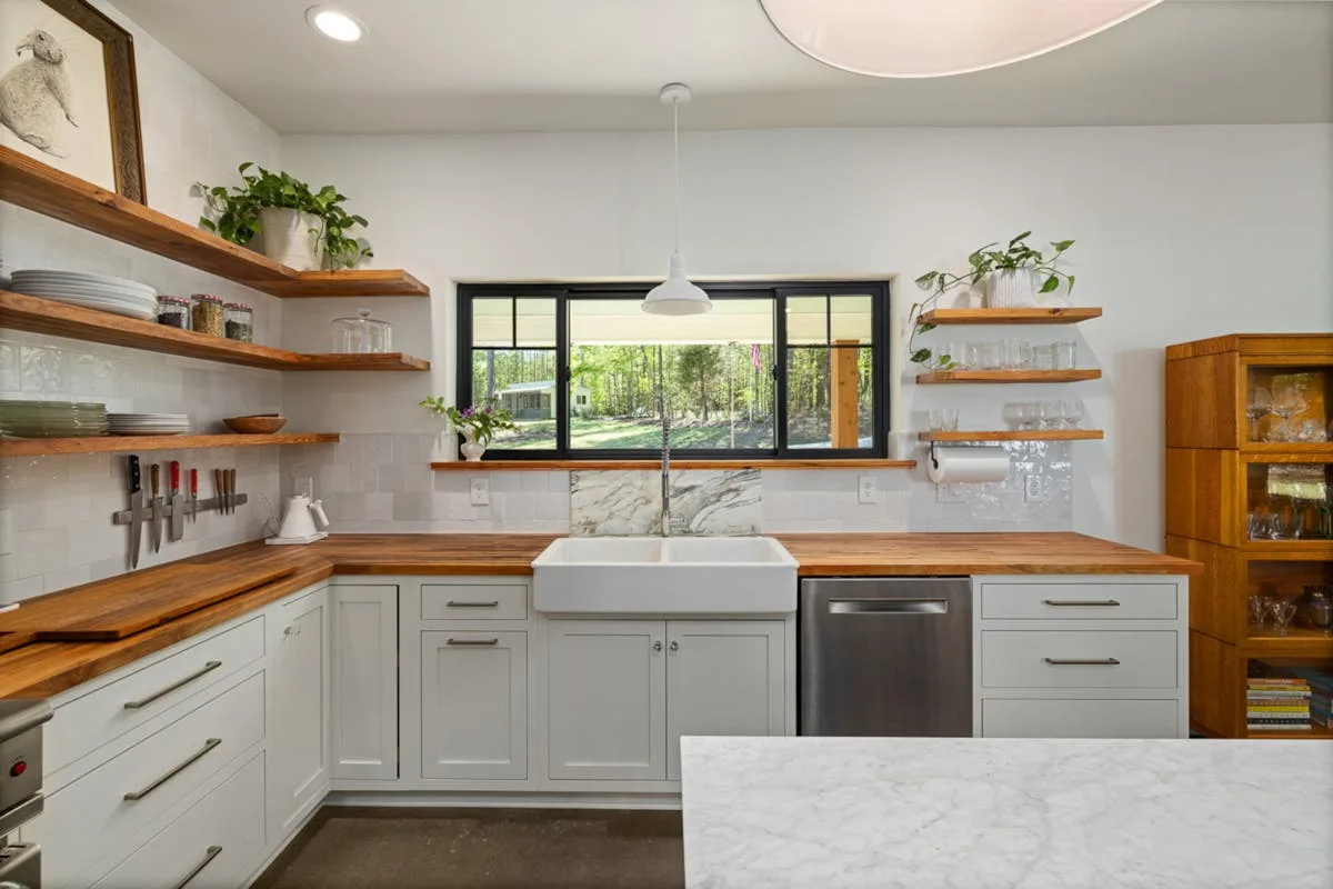 Open wood shelves holding dishes in a small apartment kitchen
