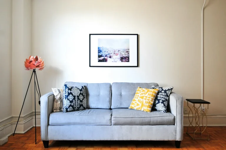 Light grey sofa with throw pillows in a bright small apartment living room