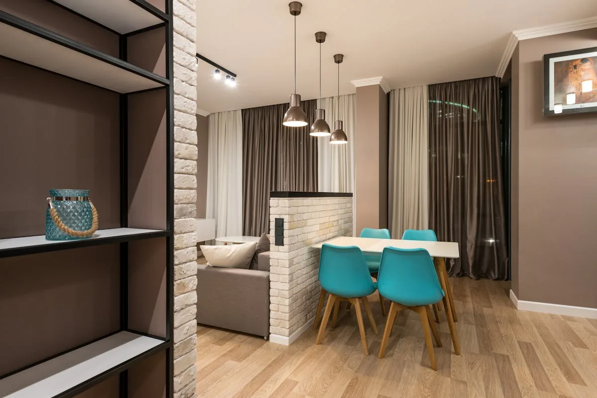 Open shelving unit dividing a studio into a living area and a dining zone