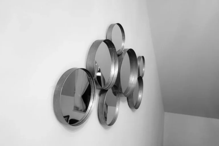 Cluster of round mirror discs arranged on a white wall