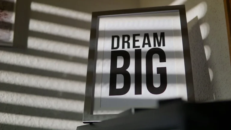 Inspirational DREAM BIG sign on a wall with window light