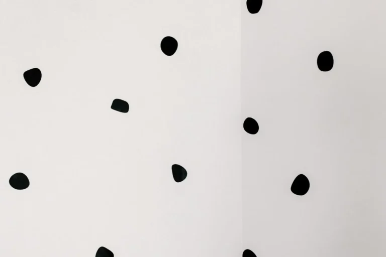 White wall with scattered black polka dot decals