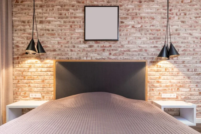 Red brick accent wall behind a bed in a modern bedroom